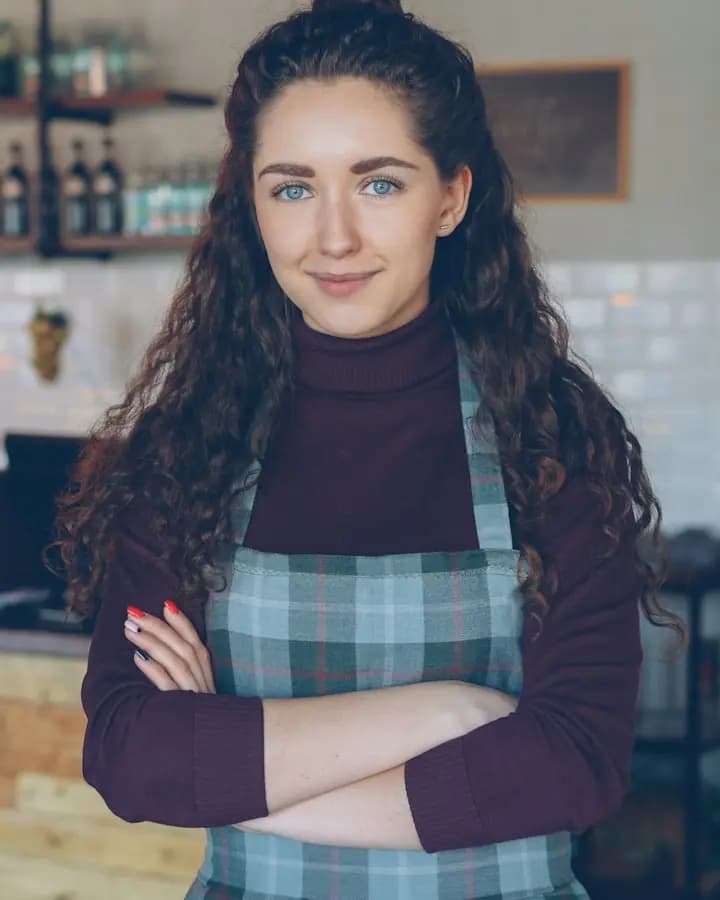 Commerçante souriante devant le comptoir de son café